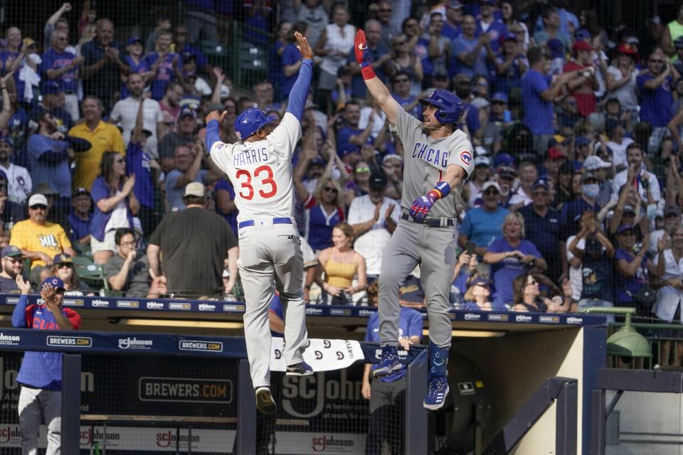 Chicago Cubs' Patrick Wisdom celebrates with third base coach Willie Harris (33) after hitting a three-run home run during the eighth inning of a baseball game against the Milwaukee Brewers Sunday, Sept. 19, 2021, in Milwaukee. (AP Photo/Morry Gash)