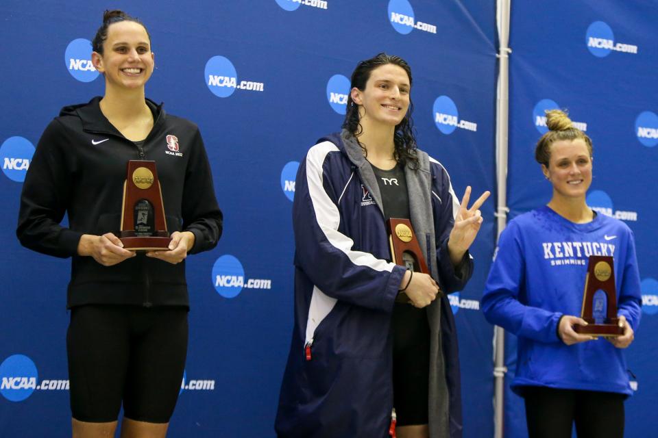 Penn Quakers swimmer Lia Thomas stands between Stanford Cardinal swimmer Lillie Nordmann Kentucky Wildcats swimmer Riley Gaines after finishing fifth in the 200 free at the NCAA Swimming & Diving Championships at Georgia Tech on March 18, 2022 in Atlanta.