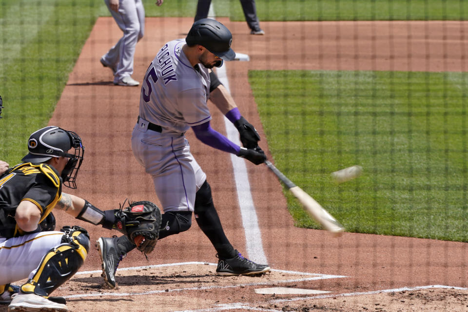 Colorado Rockies' Randal Grichuk doubles off Pittsburgh Pirates relief pitcher Zach Thompson, driving in two runs during the second inning of a baseball game in Pittsburgh, Wednesday, May 25, 2022. (AP Photo/Gene J. Puskar)