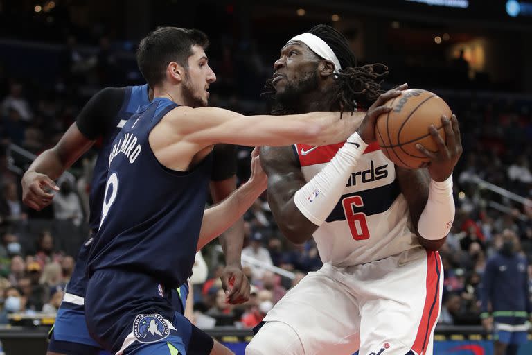 Leandro Bolmaro lucha por el balón con Montrezl Harrell