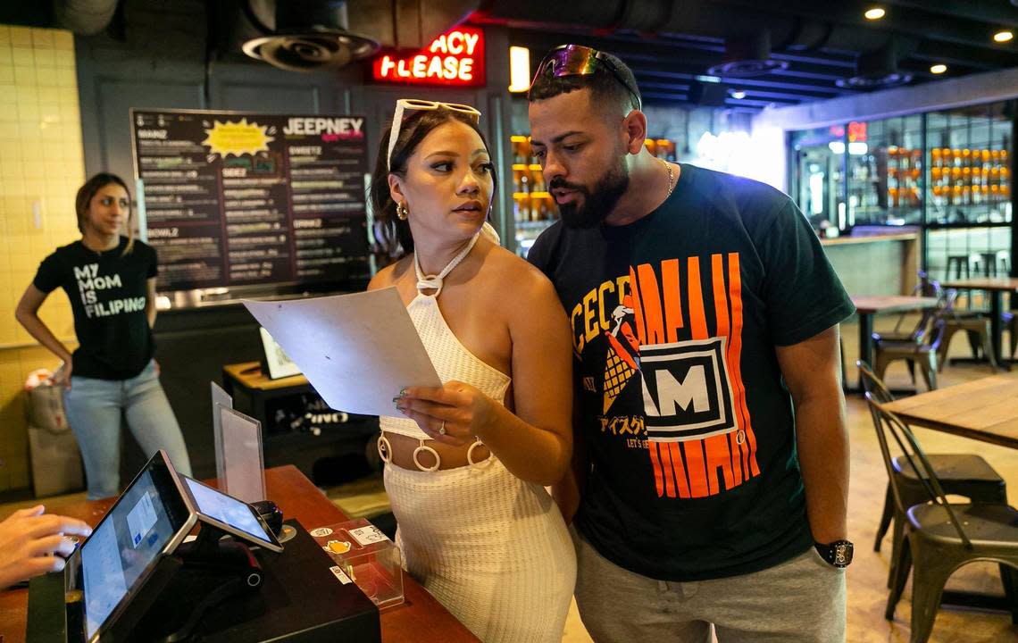 Aileen Vasquez, 28, and her boyfriend, Daniel Brown, 28, both from Orlando, look over the menu at Chinese restaurant Yip in 1-800-Lucky food hall in Wynwood.