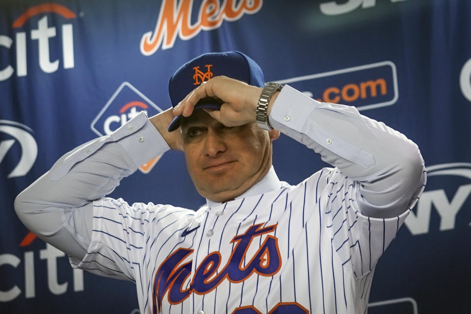 New York Mets new manager Carlos Mendoza puts on a team hat during an introductory baseball press conference at Citifield in New York, Tuesday, Nov. 14 2023. (AP Photo/Bebeto Matthews)