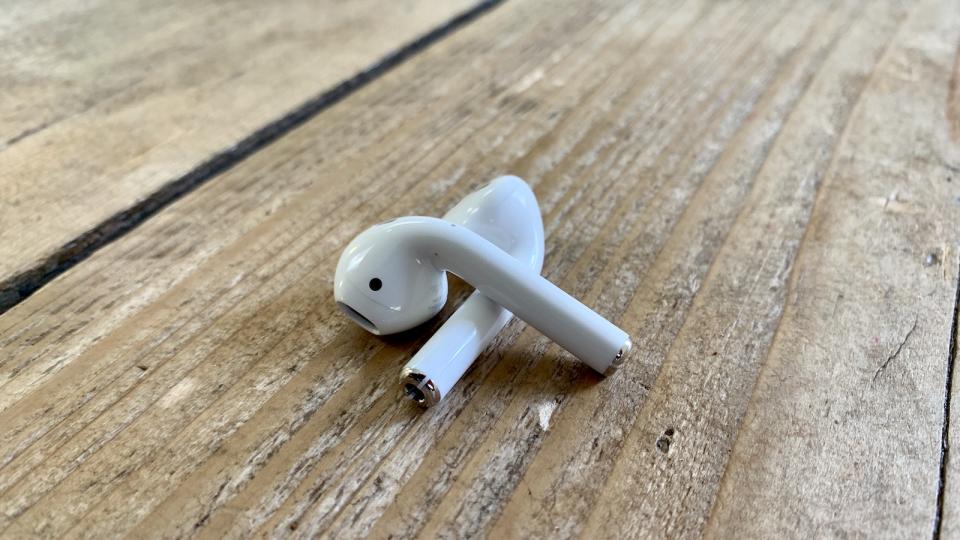 AirPods earbuds criss-crossed on a wooden table