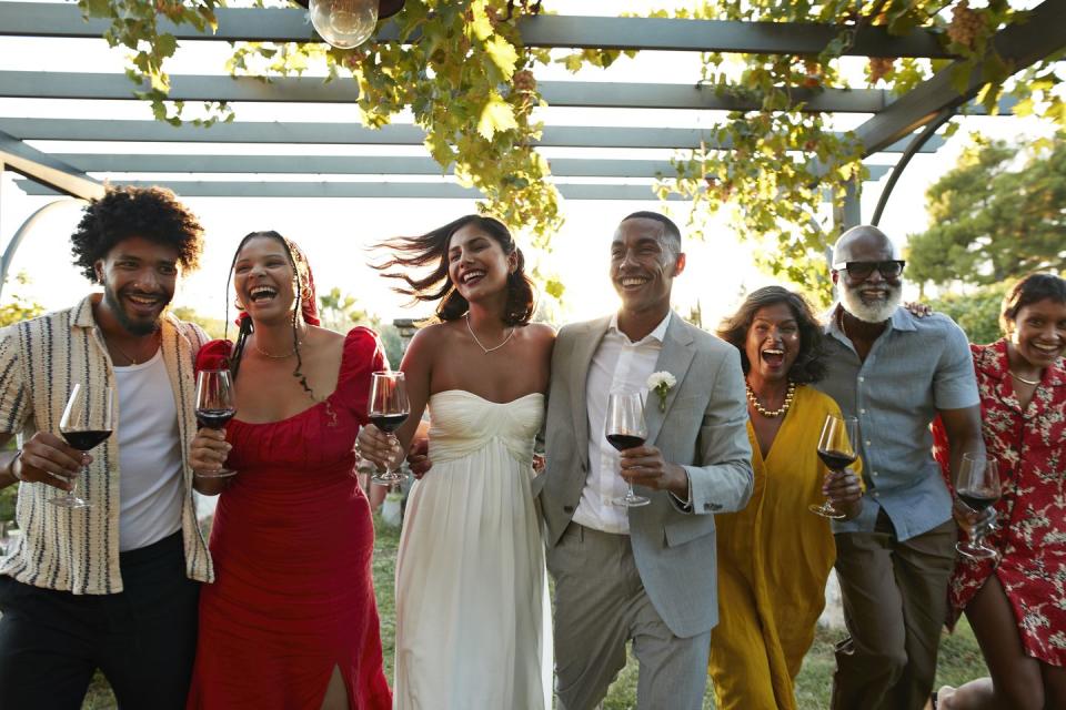 cheerful married couple and wedding guests