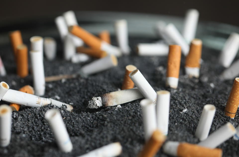 FILE - This March 28, 2019, file photo shows cigarette butts in an ashtray in New York. Two of the hottest trends in investing are working in tandem to steer billions of dollars toward companies seen as the best corporate citizens. The sustainable investing field in its early days attracted investors by avoiding so-called “sin stocks”-- gun makers, cigarette manufacturers, etc. (AP Photo/Jenny Kane, File)