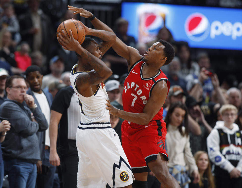 Denver Nuggets forward Will Barton, left, looks to pass the ball as Toronto Raptors guard Kyle Lowry defends in the first half of an NBA basketball game Sunday, March 1, 2020. (AP Photo/David Zalubowski)