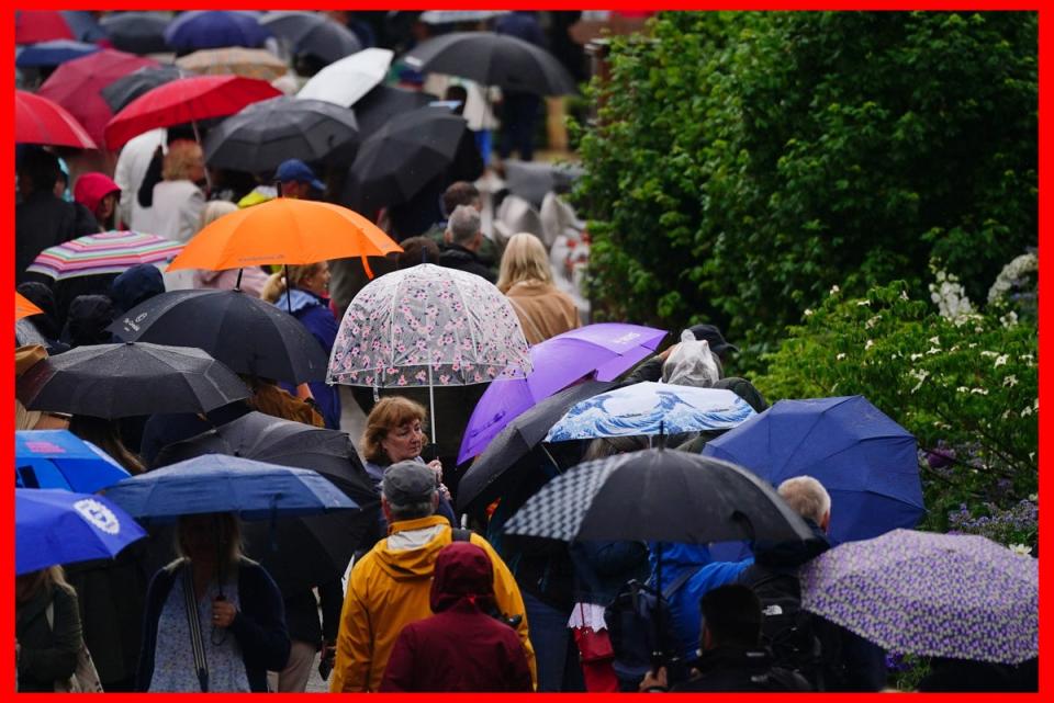 Members of the public shelter under umbrellas the RHS Chelsea Flower Show in London on Wednesday (Victoria Jones/PA Wire)