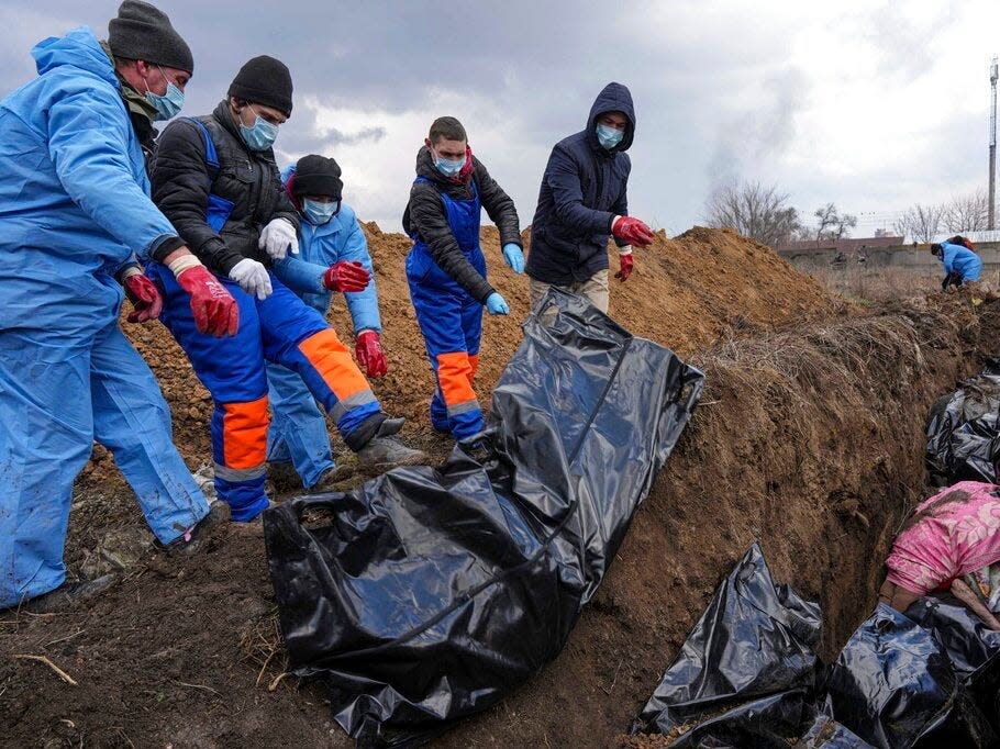 Dead bodies are placed into a mass grave on the outskirts of Mariupol, Ukraine, Wednesday, March 9, 2022, as people cannot bury their dead because of the heavy shelling by Russian forces.