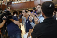 An unidentified man is taken out as he interrupts Florida Gov. Ron DeSantis, Monday, June 14, 2021, at the Shul of Bal Harbour, a Jewish community center in Surfside, Fla. DeSantis visited the South Florida temple to denounce anti-Semitism and stand with Israel, while signing a bill into law that would require public schools in his state to set aside moments of silence for children to meditate or pray. (AP Photo/Wilfredo Lee)