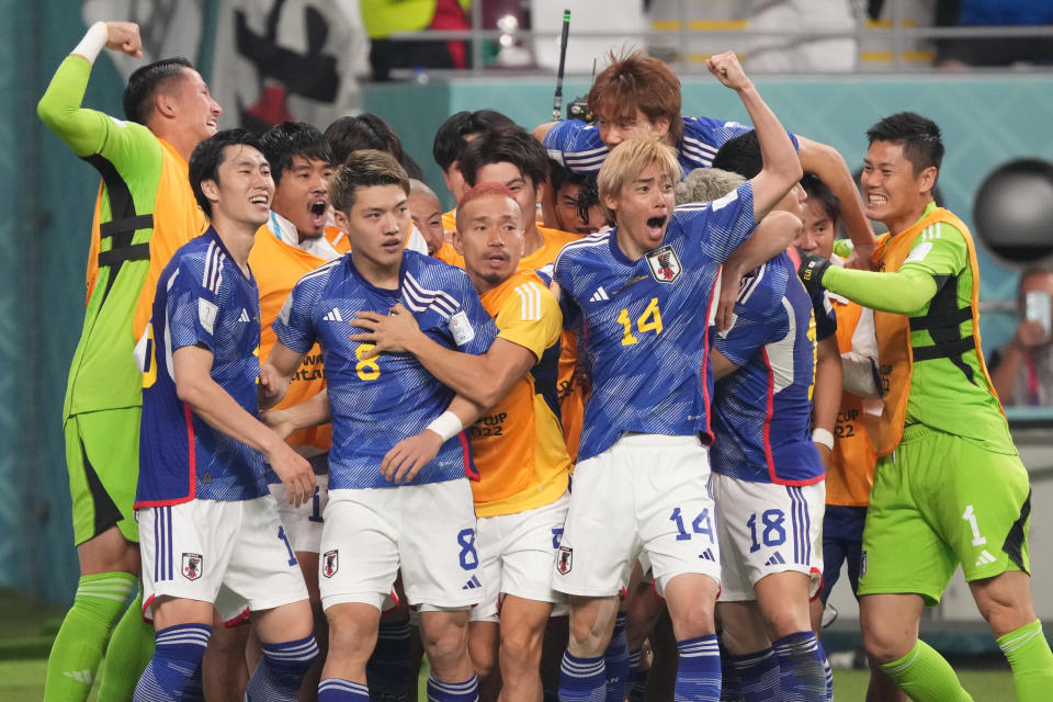 Japan players celebrate scoring against Germany during their 2022 World Cup Group E match. 