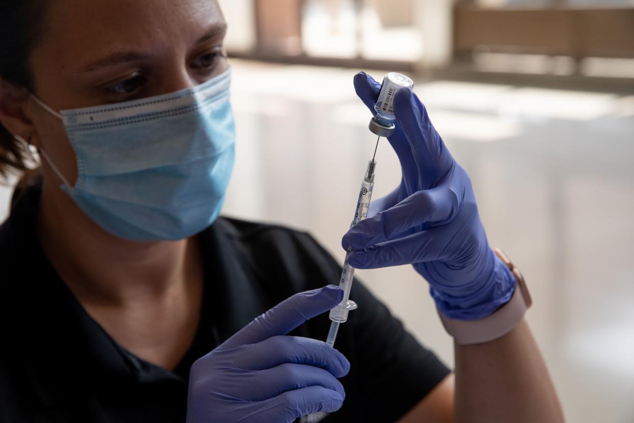 Oakland County Health Department emergency preparedness specialist Jeanette Henson fills syringes with doses of the coronavirus (COVID-19) vaccine on Aug. 24, 2021, at the Southfield Pavilion in Southfield, Mich.