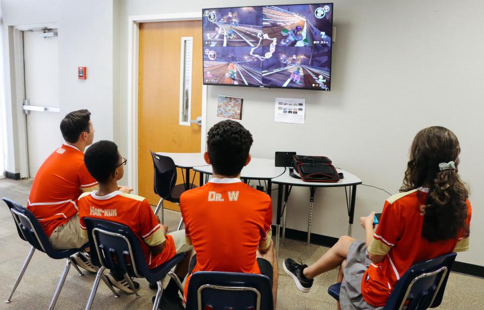 Young gamers on Greater Atlanta Christian School's esports team play Mario Kart together. Their gamer tags are on the back of their jerseys.