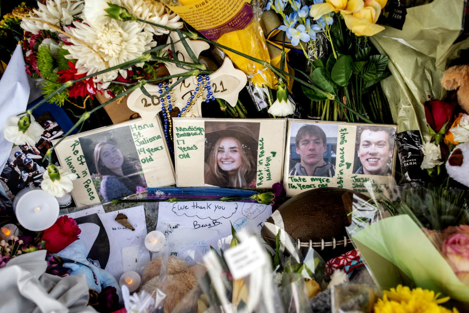 Photographs of four students —Hana St. Juliana, 14, Madisyn Baldwin, 17, Tate Myre, 16 and Justin Shilling, 17 — sit among boquets of flowers, teddy bears and other personal items left at the memorial site on Tuesday, Dec. 7, 2021 outside Oxford High School in Oxford, Mich., after a 15-year-old allegedly killed these four classmates, and injured seven others in a shooting inside the northern Oakland County school one week earlier. (Jake May/The Flint Journal via AP)