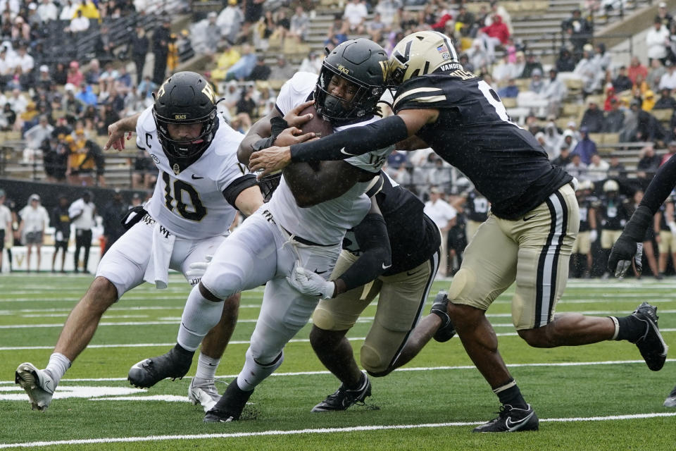 Wake Forest running back Justice Ellison, center, is hit by Vanderbilt cornerback Tyson Russell, right, in the second half of an NCAA college football game Saturday, Sept. 10, 2022, in Nashville, Tenn. (AP Photo/Mark Humphrey)