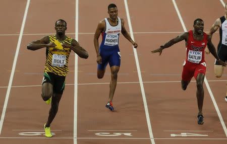 Usain Bolt Jamaica (L) celebrates winning the race ahead of Justin Gatlin of U.S. (R) who finished in second and Zharnel Hughes of Great Britain in the men's 200 metres final during the 15th IAAF World Championships at the National Stadium in Beijing, China August 27, 2015. REUTERS/Fabrizio Bensch