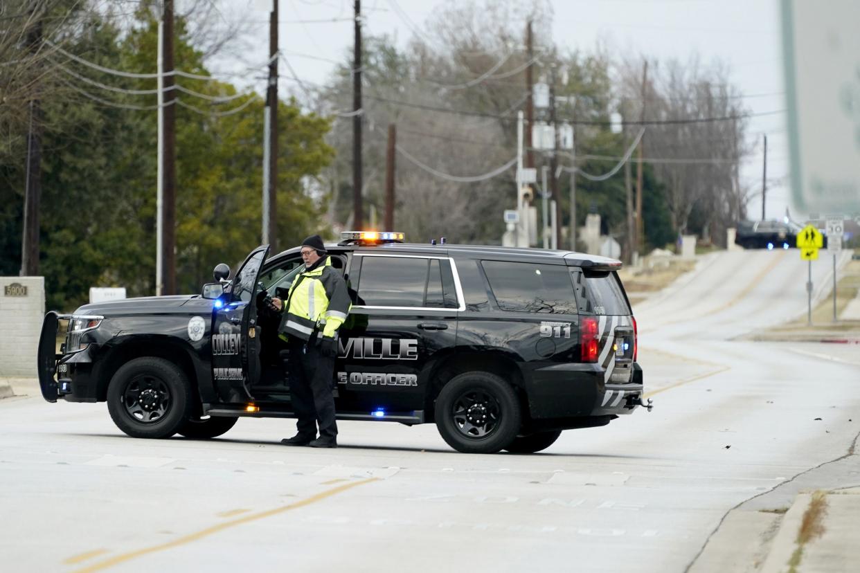 Law enforcement officials block Pleasant Run Rd. near Congregation Beth Israel synagogue where a man took hostages during services on Saturday, Jan. 15, 2022, in Colleyville, Texas.