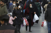 People shop in the Grand Bazaar of Tehran, Iran, Saturday, Jan. 22, 2022. Iran has found a rare, if fleeting, respite from the anxiety and trauma of the pandemic. After successive virus waves pummeled the country for nearly two years, belated mass vaccination under a new, hard-line president has, for a brief moment, left the stricken nation with a feeling of apparent safety. (AP Photo/Vahid Salemi)