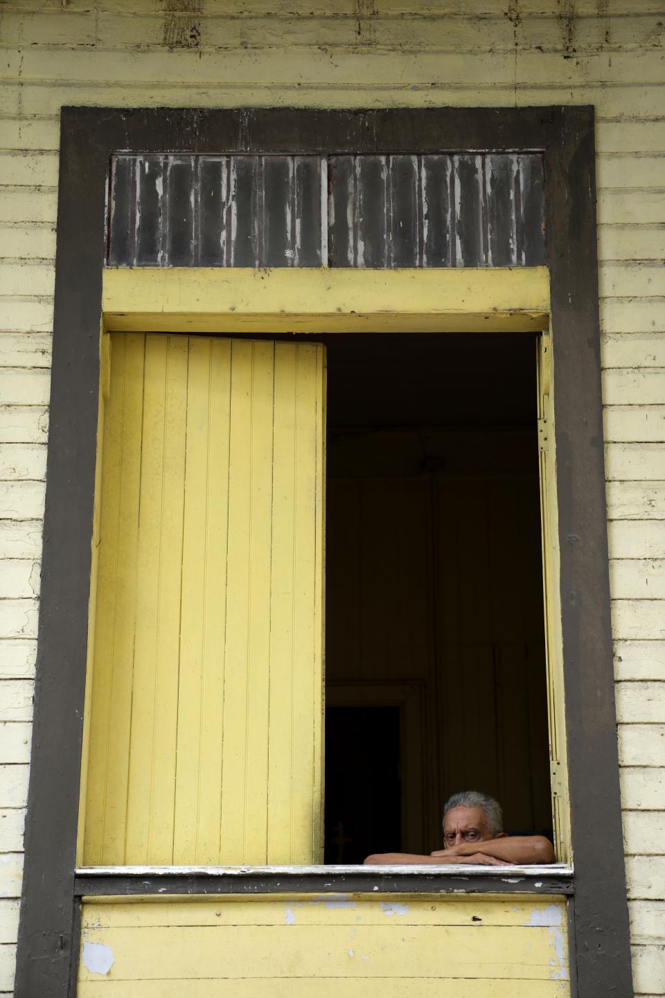 Un hombre mira desde una casa en la zona del Casco Antiguo de la Ciudad de Panamá, el lunes 7 de junio de 2021, en medio de la pandemia de COVID-19. (AP Foto/Arnulfo Franco)