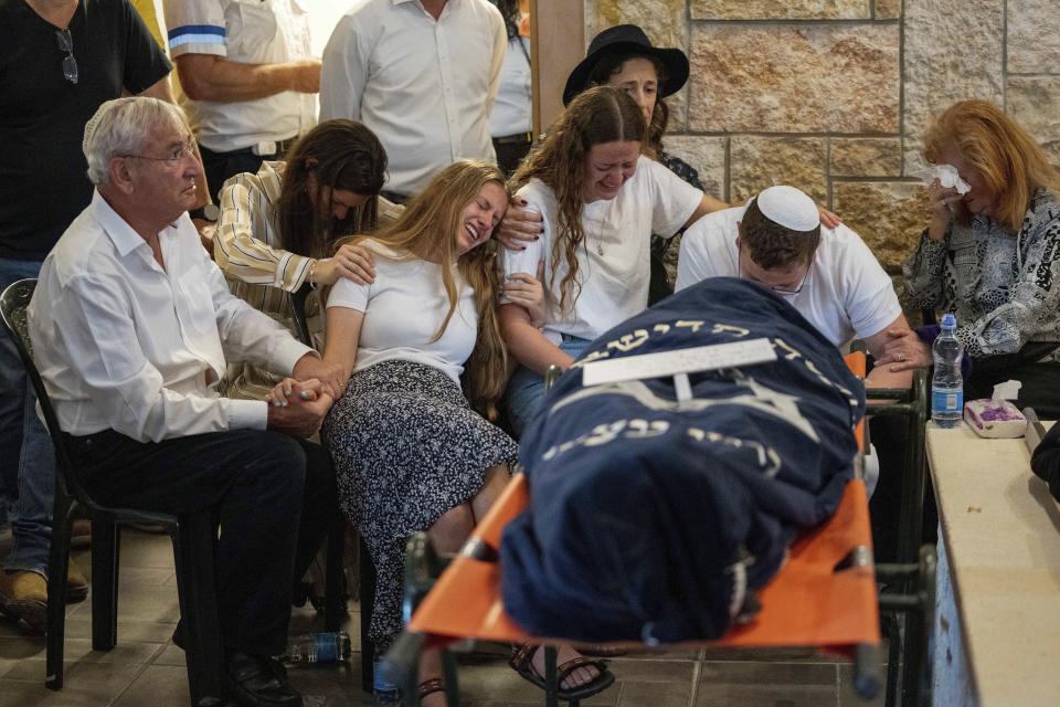 Mourners attend the funeral of two British-Israeli sisters, Maia and Rina Dee, at a cemetery in the West Bank Jewish settlement of Kfar Etzion, Sunday, April 9, 2023. The two sisters were killed in a shooting attack on Friday by Palestinian gunmen in the West Bank. (AP Photo/Ohad Zwigenberg)