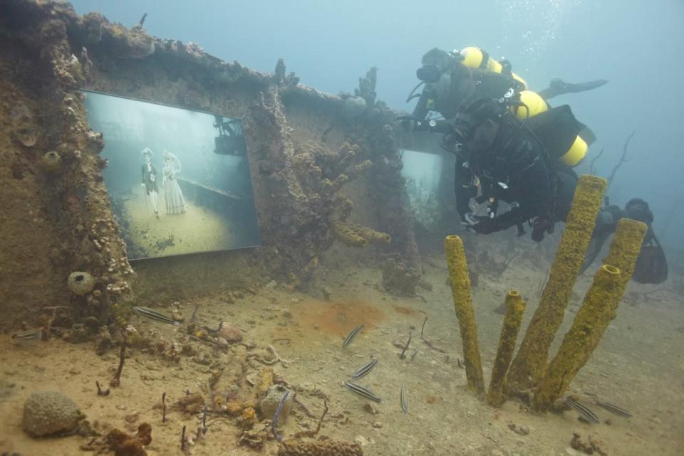 Un par de buzos recorre la exhibición "The Sinking World" en el naufragado barco "SS Stavornikita", en las aguas de Barbados, en el mar Caribe.