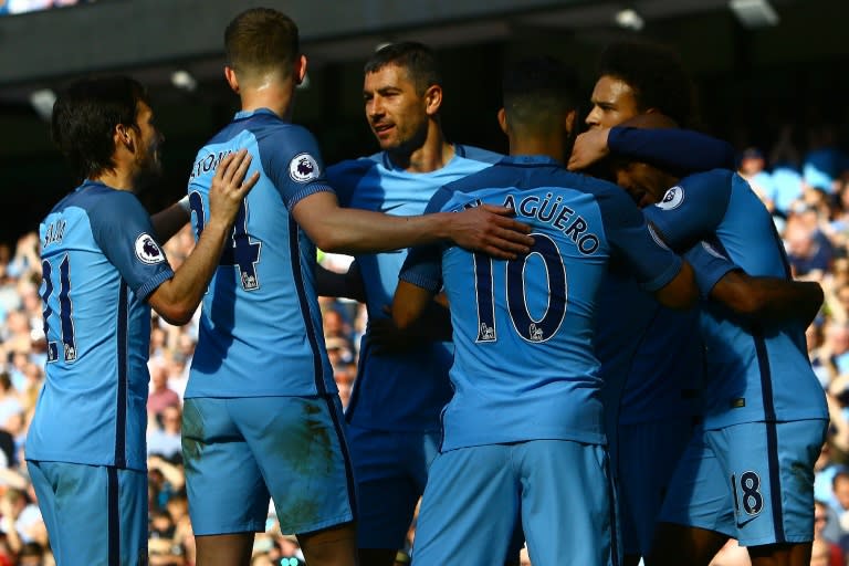 Manchester City's English Fabian Delph (R) celebrates scoring his team's third goal against Hull City at the Etihad Stadium in Manchester, north west England, on April 8, 2017