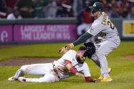 Boston Red Sox's Marwin Gonzalez, left, is tagged out by Oakland Athletics third baseman Matt Chapman after getting caught in a run down during the fifth inning of a baseball game, Wednesday, May 12, 2021, in Boston. (AP Photo/Charles Krupa)