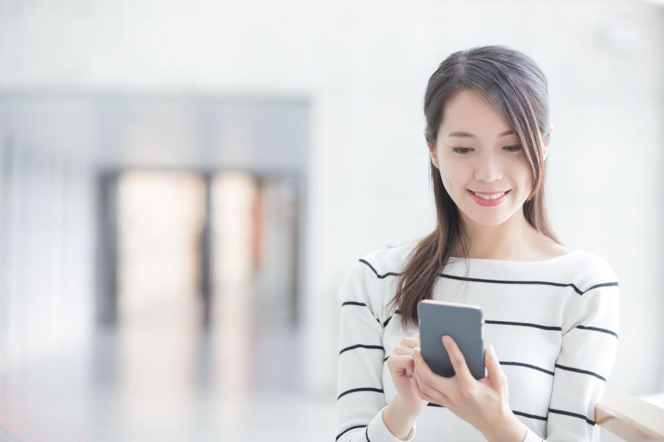 A young woman uses her smartphone.