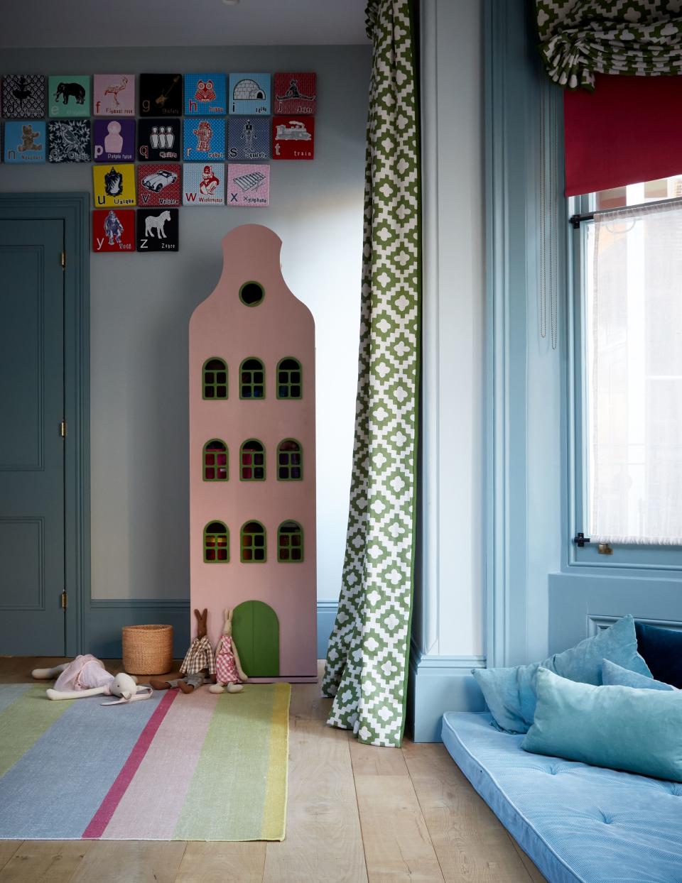 A layered approach to window dressing adds levity to the muted color scheme. Here, the combination of a red roller blind outfitted in Decorex fabric, a privacy panel in Casamance fabric, and a curtain made with a pattern by Peter Dunham Textiles is both playful and posh.