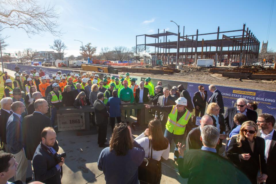 Gov. Laura Kelly shakes hands with construction workers before taking a group photo during a beam signing ceremony Monday for the new Docking State Office Building.