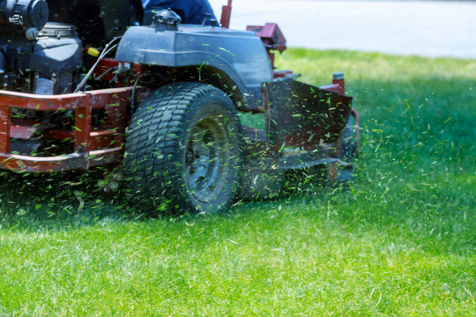 Red Lawn mower cutting grass. Gardening concept background