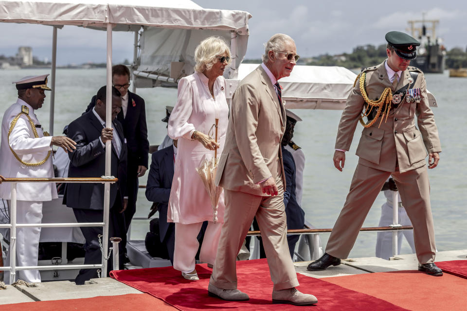 Britain's King Charles III, center, and Queen Camilla arrive aboard the Admiral's Barge to meet Royal Marines and Kenyan Marines at Mtongwe Naval Base, in Mombasa, Kenya, Thursday, Nov. 2, 2023. (Luis Tato/Pool Photo via AP)