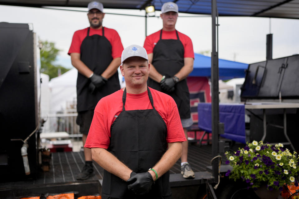 Members of the Pig Diamonds BBQ Team, Brent Little, center, Adriano Pedro, left, and John Borden, right, watch as judges taste their entry at the World Championship Barbecue Cooking Contest, Saturday, May 18, 2024, in Memphis, Tenn. The team is comprised of members from Brazil and the United States. (AP Photo/George Walker IV)