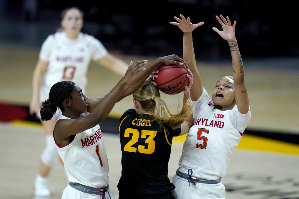 Iowa forward Logan Cook (23) faces pressure from Maryland guard Diamond Miller (1) and forward Alaysia Styles (5) during the second half of an NCAA college basketball game, Tuesday, Feb. 23, 2021, in College Park, Md. Maryland won 111-93. (AP Photo/Julio Cortez)