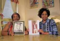 In this Wednesday, April 10, 2019, photo Mylinda Byrd Washington, 66, left, and Louvon Byrd Harris, 61, hold up photographs of their brother James Byrd Jr. in Houston. James Byrd Jr. was the victim of what is considered to be one of the most gruesome hate crime murders in recent Texas history. (AP Photo/Juan Lozano)