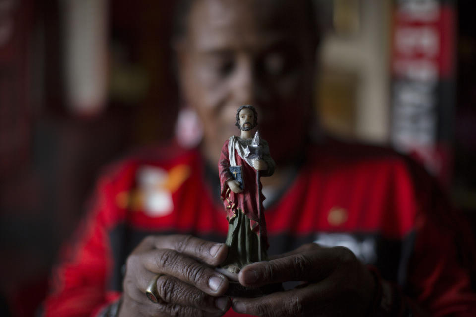 In this April 28, 2014 photo, Maria Boreth de Souza, alias Zica, shows her statue of San Judas Tadeu, or Saint Jude, considered by fans the patron saint of Flamengo's soccer team, at her home in the Olaria neighborhood of Rio de Janeiro, Brazil. "I lived on the streets for 10 years begging for food and money, doing odd jobs here and there and selling candies. I never stole or got involved with drugs." Things started to change when she was wondering aimlessly down the streets of Rio at the age of 17, when the mother of then rising soccer star Zico invited her for dinner. (AP Photo/Leo Correa)