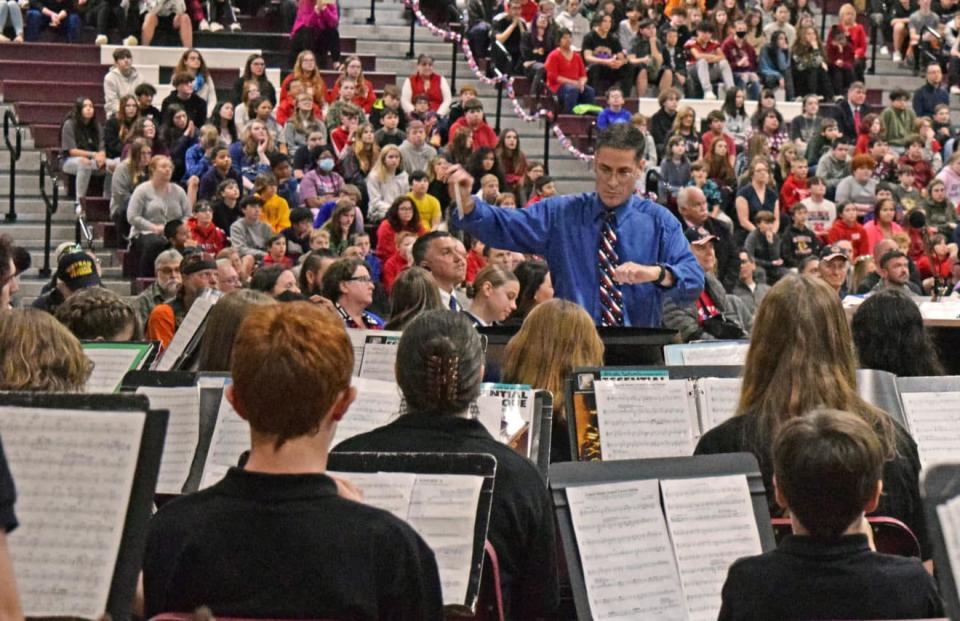 Rochester Middle School Band Director Eric Diamond leads student musicians in a song.