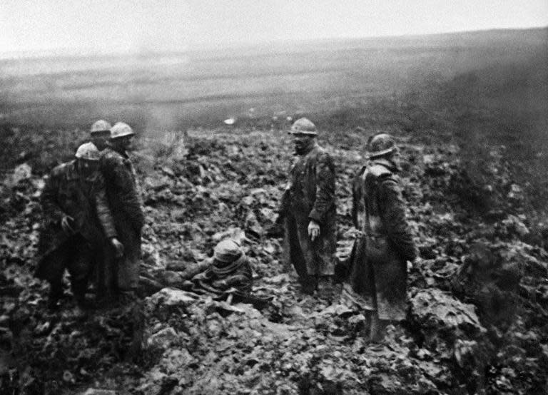 (FILES) - A picture taken in 1916 shows Poilus, French World War I infantrymen, taking care of wounded soldiers on a battlefield after an attack during the Verdun battle, eastern France, during the first World War. The battle won by the French in November 1916 cost the life of 163.000 French soldiers and 143.000 German soldiers. AFP PHOTO