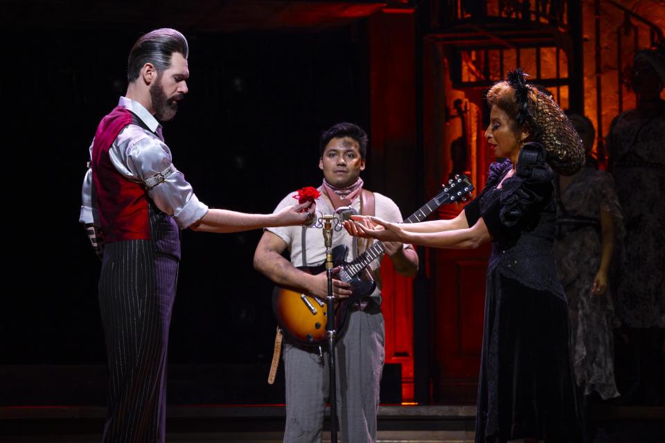 Matthew Patrick Quinn, left, as Hades, J. Antonio Rodriguez as Orpheus, and Lana Gordon as Persephone in a scene from the touring production of “Hadestown.”