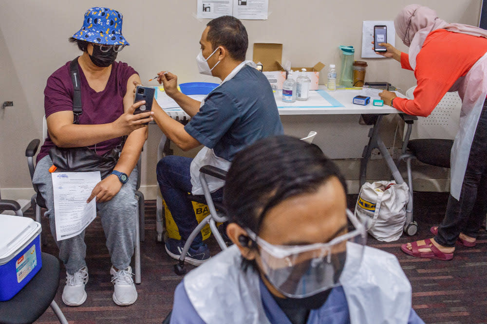 People receive their Covid-19 booster jabs at the UEM Learning Centre in Petaling Jaya, November 24, 2021. — Picture by Shafwan Zaidon