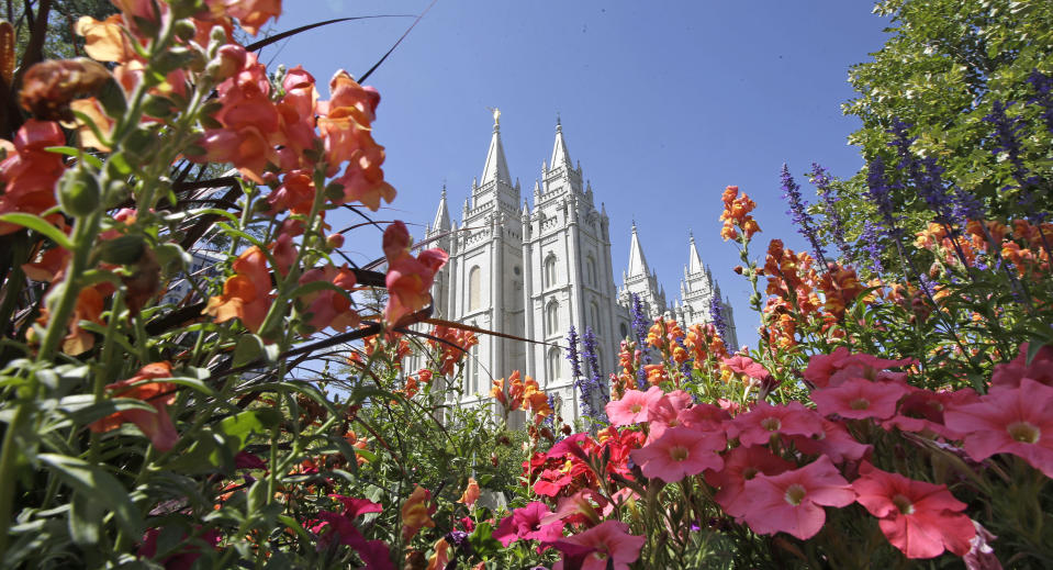 FILE - This Aug. 4, 2015 file photo, flowers bloom in front of the Salt Lake Temple, at Temple Square, in Salt Lake City. The Church of Jesus Christ of Latter-day Saints is reminding members that coffee is prohibited no matter how fancy the name, that vaping is banned despite the alluring flavors and that marijuana is outlawed unless prescribed by a competent doctor. (AP Photo/Rick Bowmer, File)