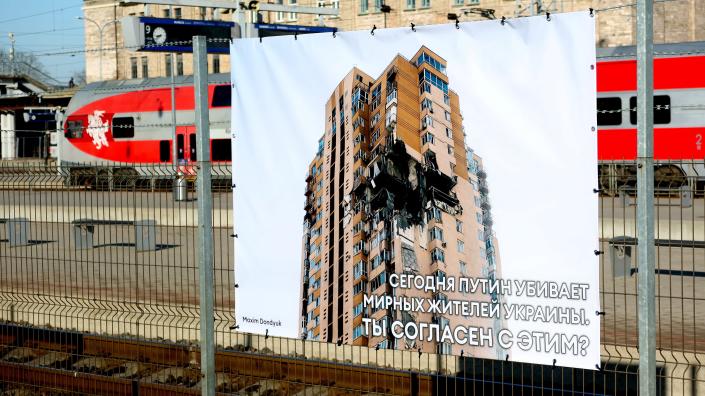 A poster with a picture taken by Ukrainian photographer Maxim Dondyuk of a damaged building is displayed for Russian passengers on their way between Kaliningrad exclave and mainland Russia at Vilnius railway station, Lithuania (REUTERS)