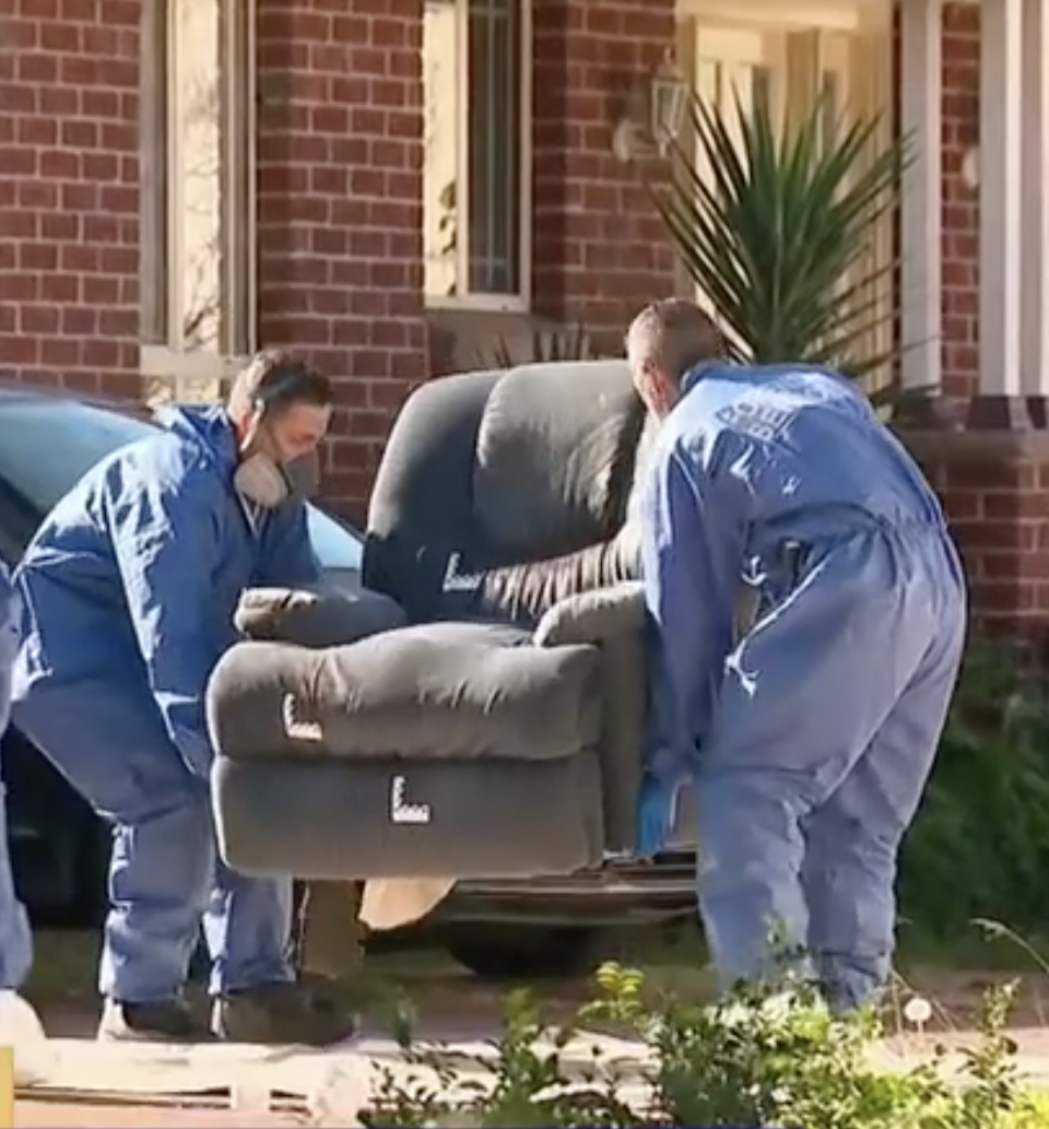 Photo shows two police officers removing a lounge chair from the home where the woman was found dead.