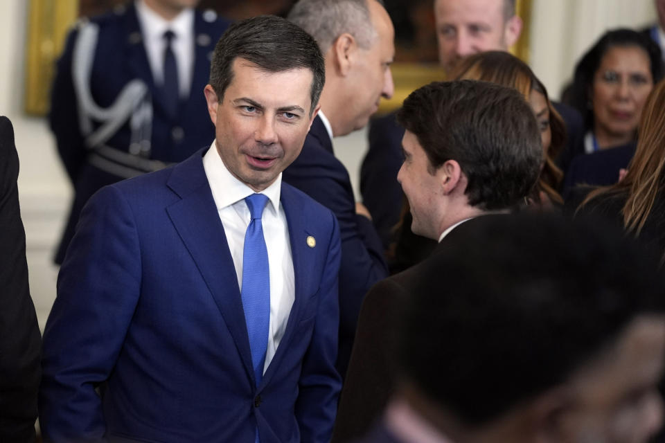 Transportation Secretary Pete Buttigieg talks before President Joe Biden speaks in the East Room during an event to welcome mayors attending the U.S. Conference of Mayors Winter Meeting to the White House, Friday, Jan. 19, 2024, in Washington. (AP Photo/Evan Vucci)