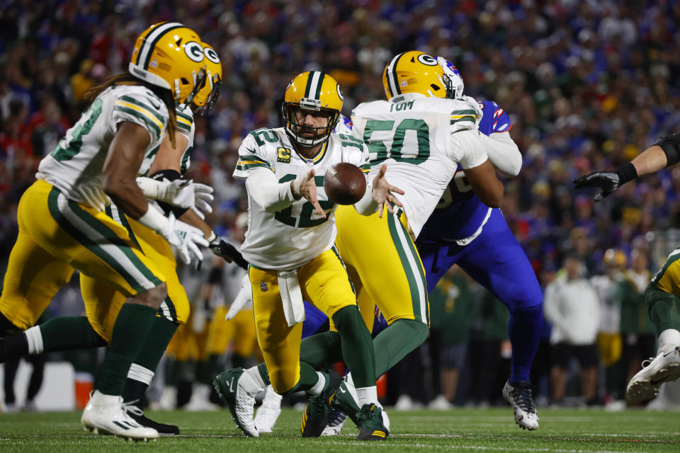 Green Bay Packers quarterback Aaron Rodgers (12) toss the ball to running back Aaron Jones (33) during the first half of an NFL football game against the Buffalo Bills Sunday, Oct. 30, 2022, in Orchard Park. (AP Photo/Jeffrey T. Barnes)
