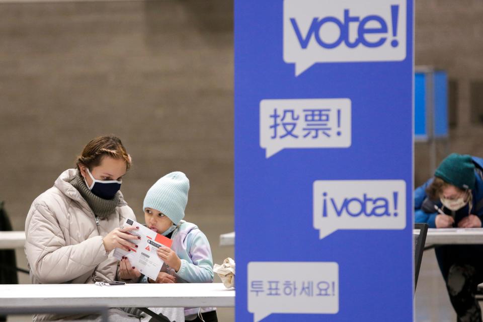 <strong>Alexis Castaneto vota por primera vez </strong>con la ayuda de su hija Luna, de cinco años, en el centro de votación temporal CenturyLink Field Event Center, en Seattle, Washington. (Photo by JASON REDMOND/AFP via Getty Images)