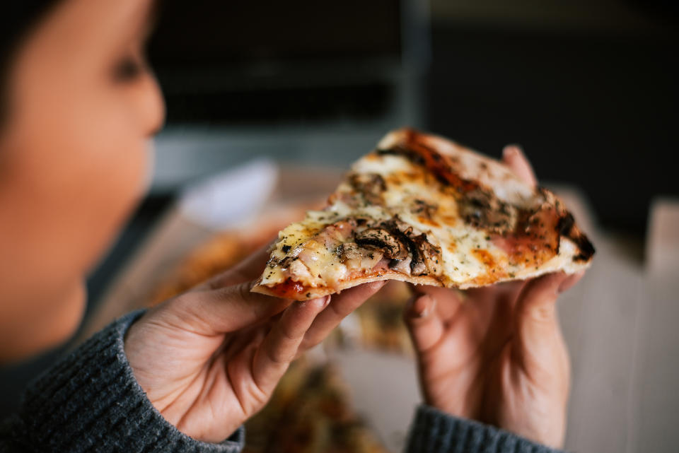 Eating pizza at night. Close-up