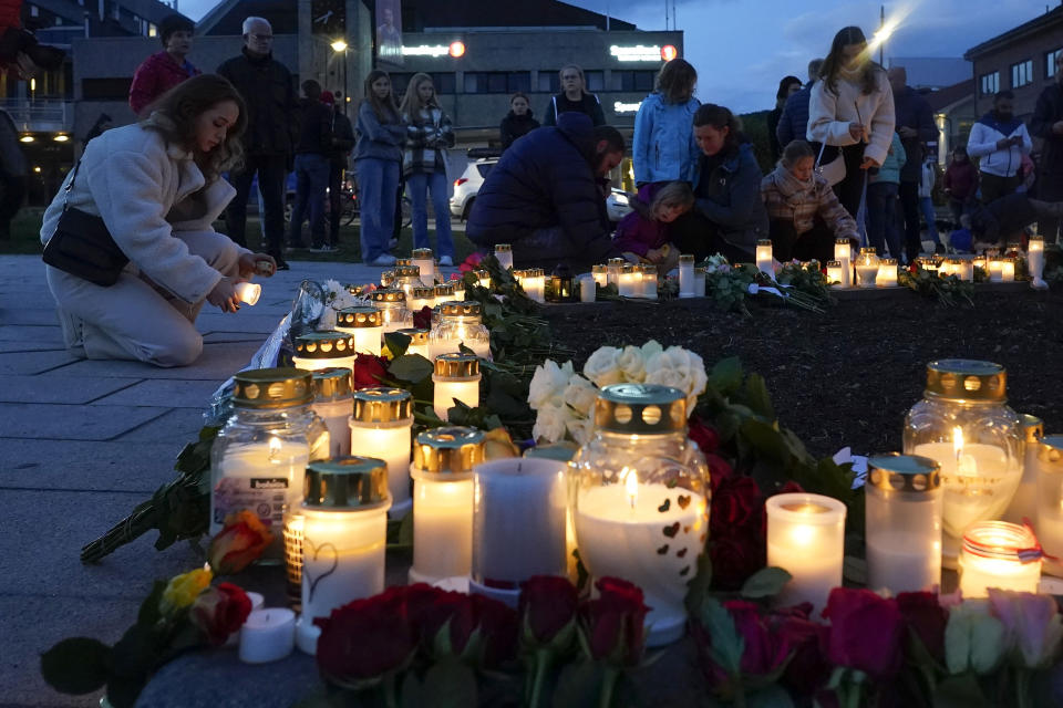 Flowers and candles are placed at the scene of an attack on the square, in Kongsberg, Norway, Thursday, Oct. 14, 2021. Norwegian authorities say the bow-and-arrow rampage by a man who killed five people in a small town appeared to be a terrorist act. Police identified the attacker as Espen Andersen Braathen, a 37-year-old Danish citizen, who was arrested Wednesday night. (Terje Bendiksby/NTB via AP)