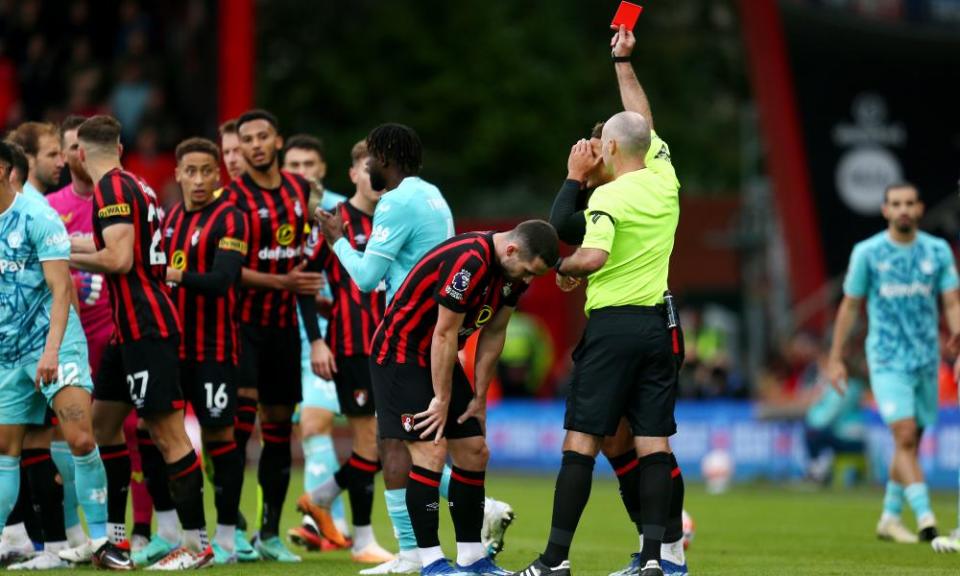 Paul Tierney shows Lewis Cook a red card.