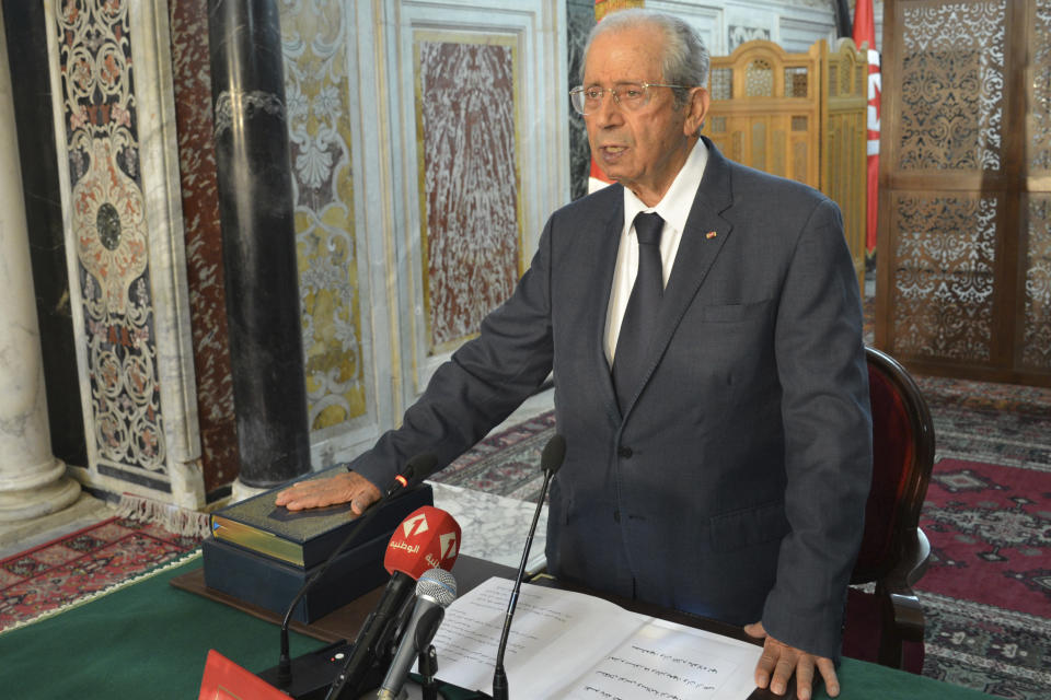 Tunisian parliament president Mohamed Ennaceur, puts his hand on the Quran to be sworn in as Tunisian interim President in Tunis, Tunisia, Thursday, July 25, 2019. Ennaceur, the leader of Tunisia's parliament has been sworn in as the interim president of the North African country after 92-year-old President Beji Essebsi died in office. The state news agency TAP reported that Mohamed Ennaceur, president of the Assembly of People's Representatives, took the oath of office Thursday July 25, hours after Essebsi's death in the morning. (Lassad Manai/Tunisian Assembly via AP)