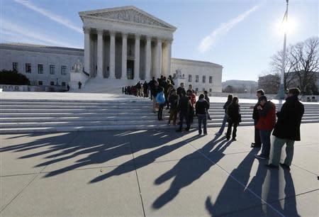 Members of the public cast shadows as they line up in front of the U.S. Supreme Court in Washington January 13, 2014. REUTERS/Larry Downing